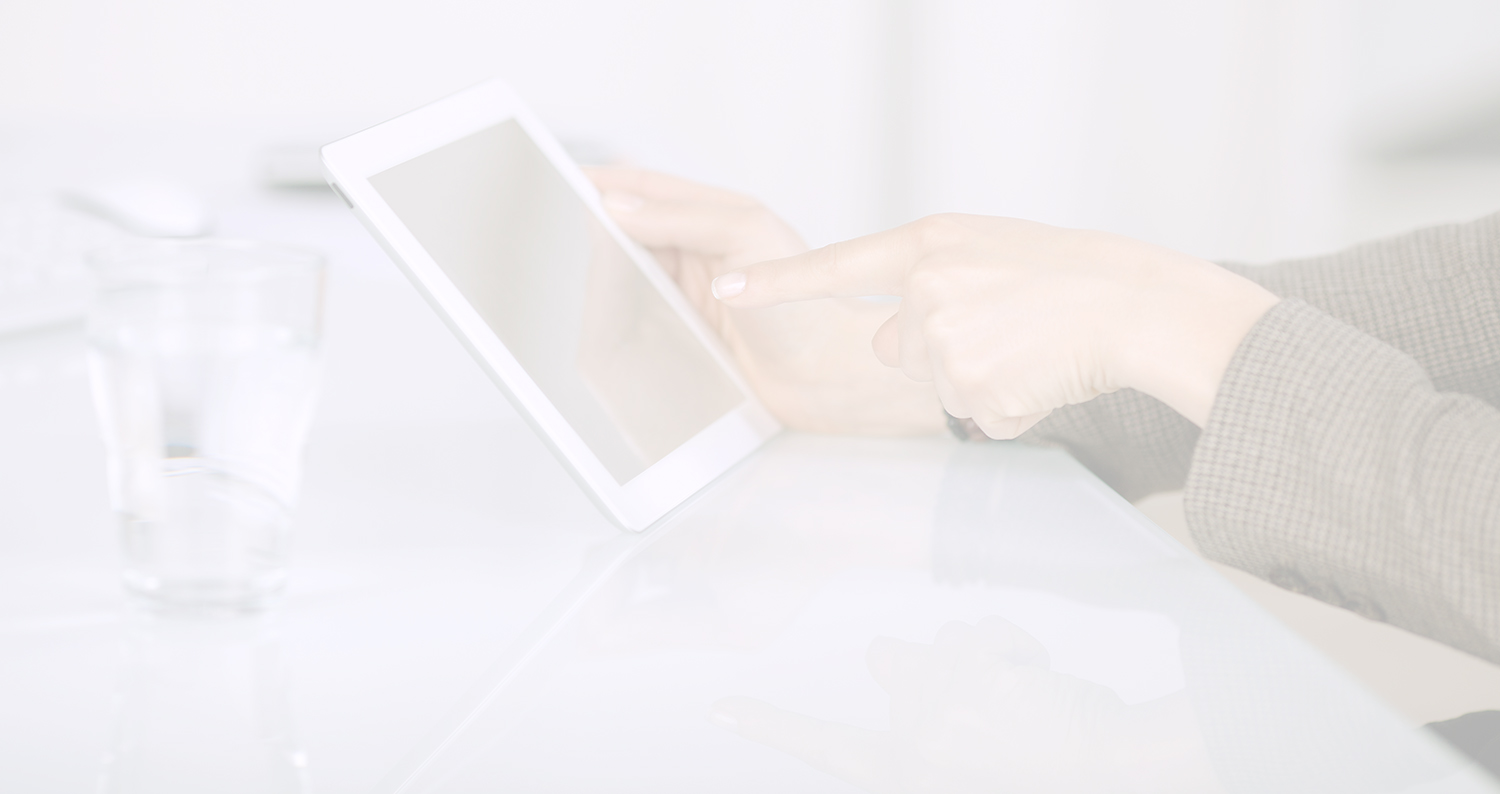 Nahaufnahme einer Hand, die einen Tablet-Bildschirm auf einem weißen Schreibtisch berührt, daneben ein Glas Wasser, sanfte helle Töne, ruhige Stimmung